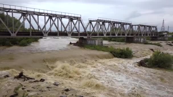 春雨期间 铁路铁桥在泥泞的河流上被洪水淹没 — 图库视频影像