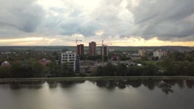 Şehir gölü yakınlarındaki inşaat halindeki yüksek apartman binalarının havadan görüntüsü. Gayrimenkul geliştirme.