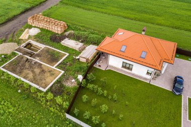 Geleceğin tuğla evi, beton temel zemini ve inşaat için sarı kil tuğla yığınları için hava manzarası.
