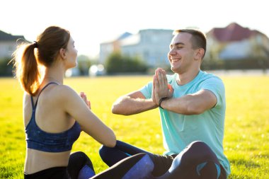 Sıcak yaz günlerinde yoga egzersizleri yapan genç bir çift..
