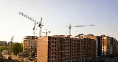 İnşaat halindeki çok katlı apartmanlar. Yüksek binaların beton ve tuğla iskeleti. Kentsel alanda gayrimenkul geliştirme.