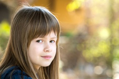 Gri gözlü, açık havada uzun sarı saçlı parlak arka planda güzel bir kızın portresi. Sıcak yaz gününde tatlı bir bayan çocuk..