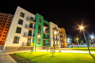 Yeşil çimenli ve modern konutlu apartmanlar arasında avlu. Gayrimenkul geliştirme.