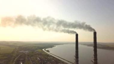 Kömür santralinden gelen gri dumanlı uzun baca borularının hava manzarası. Fosil yakıtla elektrik üretimi.