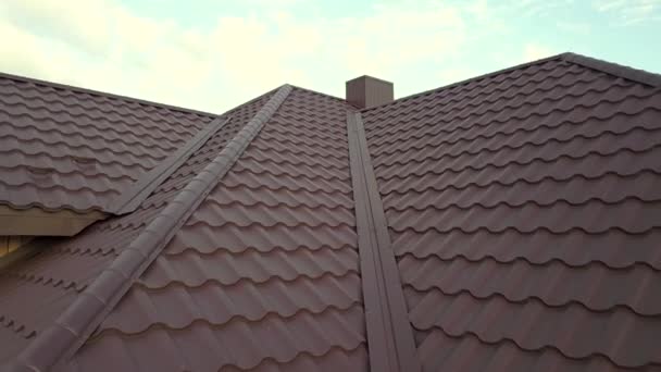 Letecký pohled na střešní konstrukci domu pokrytou kovovými dlaždicemi.