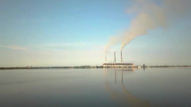 Kömür santralinden gelen gri dumanlı uzun baca borularının hava manzarası. Fosil yakıtla elektrik üretimi.