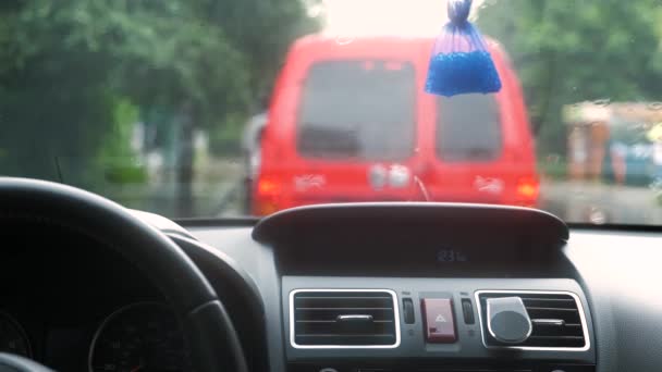 車のフロントガラスに落ちる雨の水滴の内部からのビューを閉じます — ストック動画