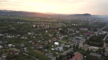 Nadvirna kasabasının hava manzarası dağınık evler ve gün batımında uzak Karpat dağ tepeleri..