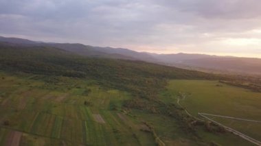 Nadvirna kasabasının hava manzarası dağınık evler ve gün batımında uzak Karpat dağ tepeleri..