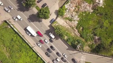 Yoğun cadde kesişiminin hareket halindeki araçlarla yukarıdan aşağı hava görüntüsü.