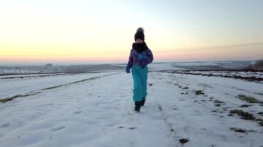 Küçük çocuk kış tarlasında eğleniyor..