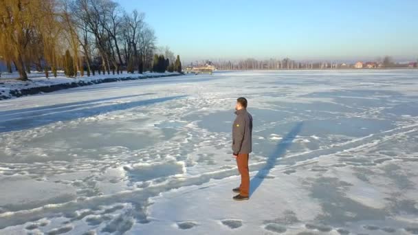 凍った湖の上に立つ男のドローン映像 — ストック動画