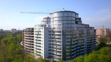Yüksek modern konut binasının ve inşaat halindeki vinç kulesinin havadan görünüşü.