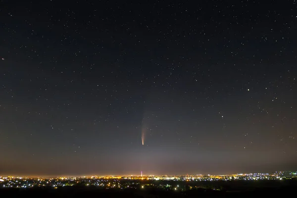 有明亮灯光的夜空和有明亮尾巴的新慧星的黑暗星空 — 图库照片