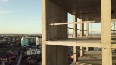 Bir şehirde inşaat halindeki tamamlanmamış uzun apartmanın beton çerçevesinin havadan görüntüsü..