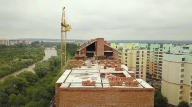 İnşaat halindeki ahşap çatısı olan bitmemiş tuğladan apartmanın havadan görüntüsü..