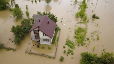 Etrafı kirli suyla çevrili su basmış evin havadan görüntüsü..