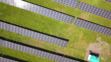 Yeşil alandaki güneş enerjisi santralinin havadan görüntüsü. Temiz ekolojik enerji üretmek için elektrik panelleri.