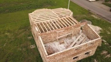 Ahşap tavan çerçeveli tuğladan bir evin havadan görünüşü.