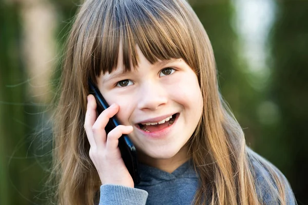 携帯電話で長い髪の少女の肖像画 小さな女性の子供がスマートフォンを使って通信しています 子どものコミュニケーションコンセプト — ストック写真