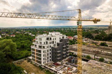 Kule görüntüsü, vinç kaldırma ve inşaat halindeki uzun apartmanın beton iskeleti. Kentsel kalkınma ve gayrimenkul büyüme kavramı.