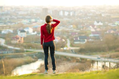 Genç bir kadın şehir manzarasının tadını çıkarıyor. Rahatlama, özgürlük ve sağIık kavramı.