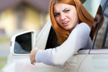 Closeup portrait of pissed off displeased angry aggressive woman driving a car. Negative human expression consept.