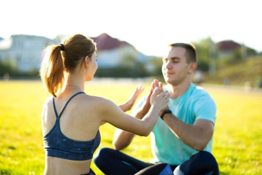 Sıcak yaz günlerinde yoga egzersizleri yapan genç bir çift..