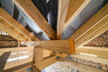 Çatısı ahşap kirişlerle ve tuğla duvarlarla inşa edilmiş bir binanın tavan arası..