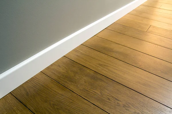 Primer Plano Zócalos Plástico Blanco Sobre Parquet Madera Oscura Roble — Foto de Stock