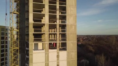 Bir şehirde inşaat halindeki tamamlanmamış uzun apartmanın beton çerçevesinin havadan görüntüsü..