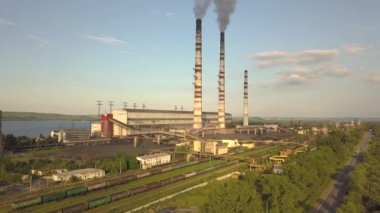 Kömür santralinden gelen gri dumanlı uzun baca borularının hava manzarası. Fosil yakıtla elektrik üretimi.