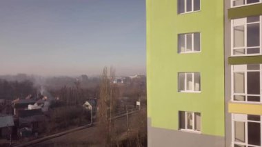 Birçok pencere ve balkonu olan yüksek bir apartman dairesinin hava görüntüleri..