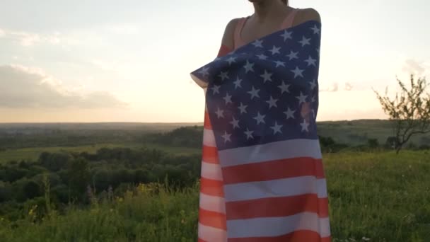 日没時にアメリカ国旗が屋外を歩く若い女性 アメリカ独立記念日を祝う正の少女 民主主義の国際デー — ストック動画