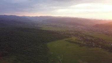 Nadvirna kasabasının hava manzarası dağınık evler ve gün batımında uzak Karpat dağ tepeleri..
