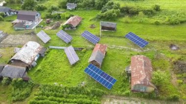 Yeşil kırsal alandaki güneş panellerinin yukarıdan aşağıya görüntüsü.