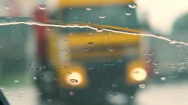 Arabanın ön camına düşen yağmur suyu damlalarını ve silecekleri kapatın..