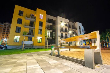 Boş ahşap bank ve modern apartman daireleri arasındaki avluda. Gayrimenkul geliştirme.