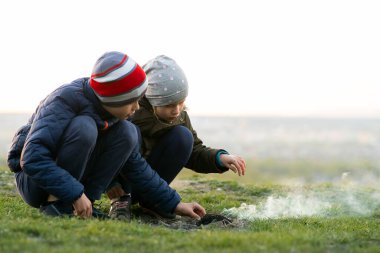 Soğuk havada dışarıda ateşle oynayan iki çocuk..