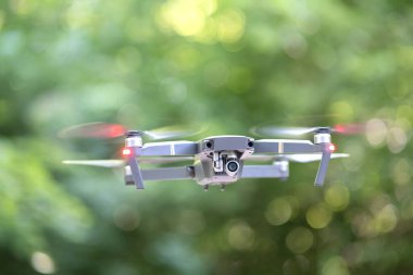 Hızla dönen pervaneleri ve havada uçuşan fotoğraf makinesi olan İHA uçakları..