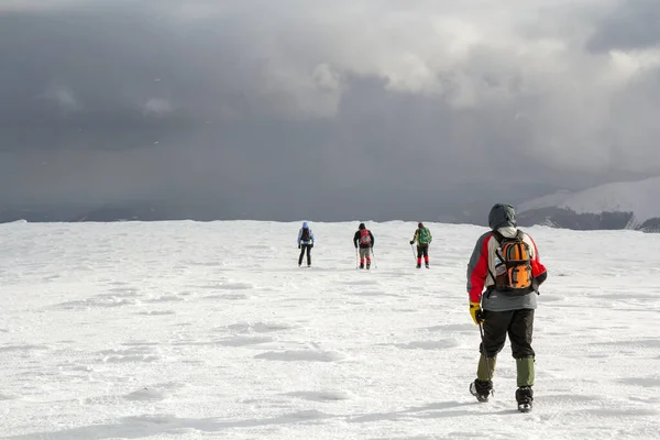 Vista Trasera Los Excursionistas Caminando Colina Cubierta Nieve Las Montañas —  Fotos de Stock