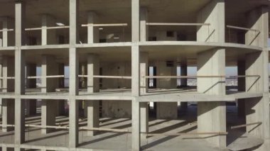 Bir şehirde inşaat halindeki yüksek apartmanın beton çerçevesinin havadan görünüşü.