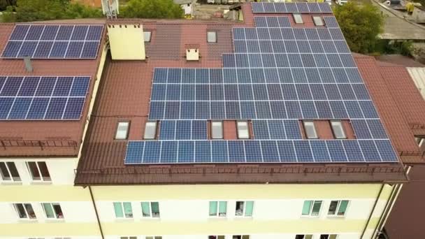 青い太陽光発電パネル付きの太陽光発電所の空中ビューマンションの建物の屋根のマウント — ストック動画