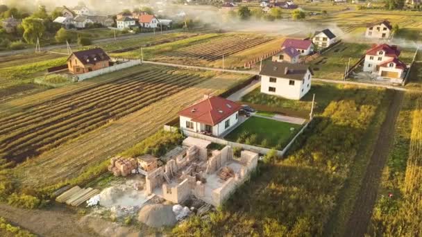 Top down aerial view of two private houses, one under construction with wooden roofing frame and another finished with red tiled roof. — Stock Footage Top Aerial View Two Private Houses One Construction Wooden Roofing Stock Footage