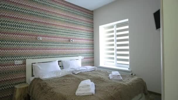 大きなダブルベッドで新鮮なリネンと広々としたホテルのベッドルームのインテリア 現代的な家の居心地の良い現代的な部屋 — ストック動画