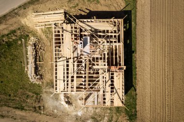 İnşaat halindeki ahşap çatı iskeleti olan bitmemiş tuğla evin havadan görüntüsü..