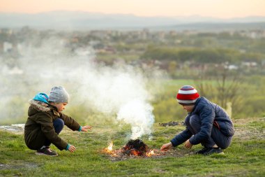 Soğuk havada dışarıda ateşle oynayan iki çocuk..