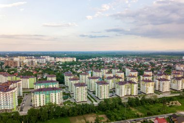 Yüksek apartman binaları ve banliyö evleri olan kentsel gelişmekte olan şehir manzarası. Drone hava fotoğrafçılığı.