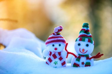 İki küçük komik oyuncak bebek kardan adam örgü şapkalı ve eşarplı açık havada açık havada açık mavi ve beyaz fotokopi arkaplanda. Mutlu yıllar ve Mutlu Noeller tebrik kartı.