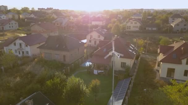 Aerial view of a residential private house with solar panels on roof and wind generator turbine. — Stock Footage Aerial View Residential Private House Solar Panels Roof Wind Generator Stock Footage